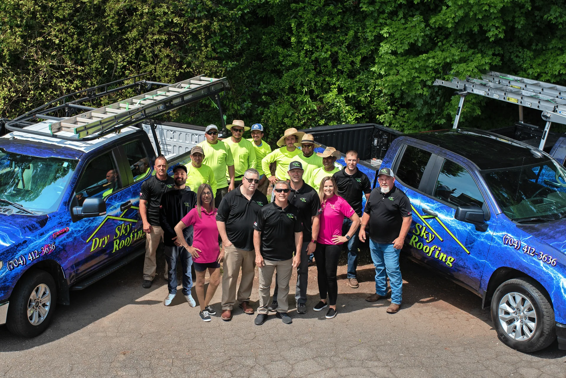 Roofing crew members with company trucks